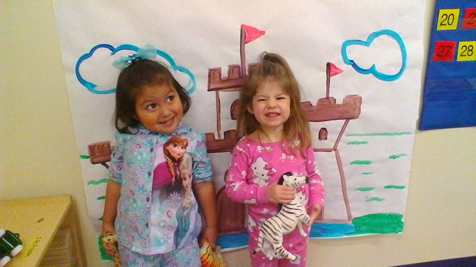 Cute little preschool girls very happy wearing cute design Frozen and Hello Kitty pajamas , holding Zebra and Tiger stuff toy, with Castle painted background, at a Preschool & Daycare/Childcare Center serving Apex & Fuquay-Varina, NC