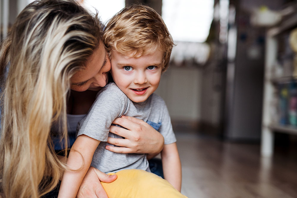 A happy mother with a toddler son indoors at home, playing. Copy space. at a Preschool & Daycare/Childcare Center serving Apex & Fuquay-Varina, NC