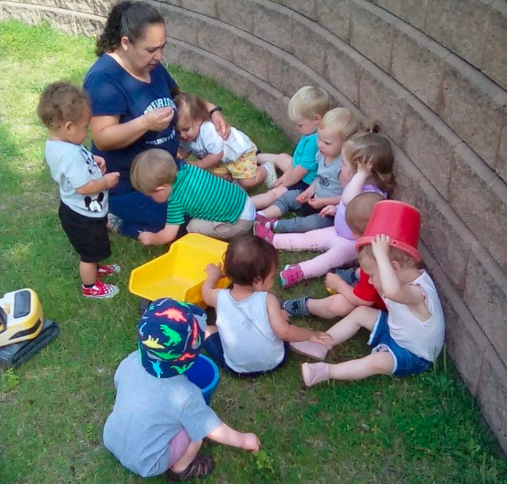 Teachers with toddlers gather around teaching and demonstrating daily kindness at a Preschool & Daycare/Childcare Center serving Apex & Teachers with toddlers gather around teaching and demonstrating daily kindness at a Preschool & Daycare/Childcare Center serving Apex & Fuquay-Varina, NCFuquay-Varina, NC