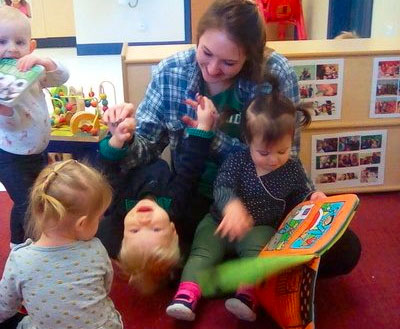 toddlers enjoy playing and reading books with teacher at a Preschool & Daycare/Childcare Center serving Apex & Fuquay-Varina, NC