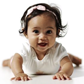 Cute little baby girl smiling while crawling, baby photo shoot concept, at a Preschool & Daycare/Childcare Center serving Apex & Fuquay-Varina, NC