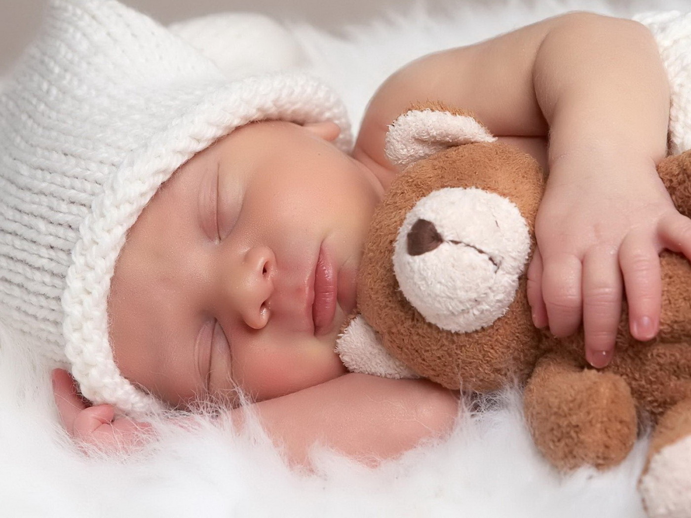 Cute sleeping baby hugging a teddy bear at a Preschool & Daycare/Childcare Center serving Apex & Fuquay-Varina, NC