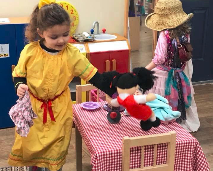 Little kid girls in costume while playing with doll at a Preschool & Daycare/Childcare Center serving Apex & Fuquay-Varina, NC