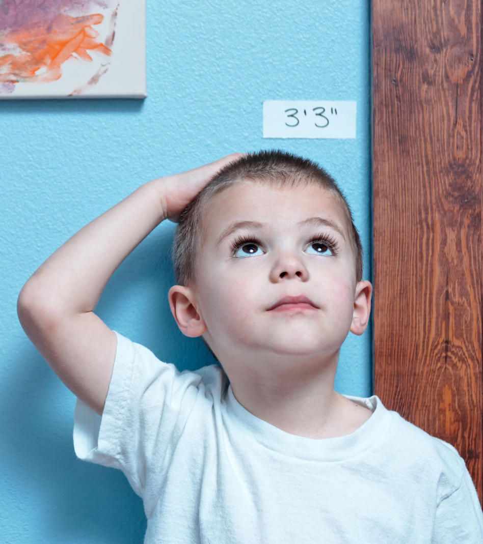 Young kid boy measuring his height at a Preschool & Daycare/Childcare Center serving Apex & Fuquay-Varina, NC