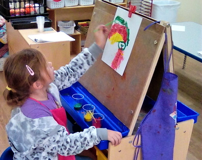 Preschool kid girl showing artistry doing paintings at a Preschool & Daycare/Childcare Center serving Apex & Fuquay-Varina, NC