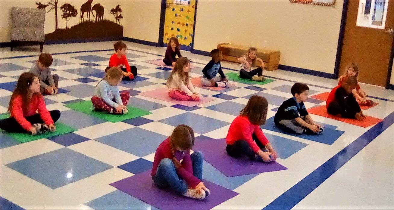 Preschoolers on positive behavior management, doing yoga inside the class at a Preschool & Daycare/Childcare Center serving Apex & Fuquay-Varina, NC