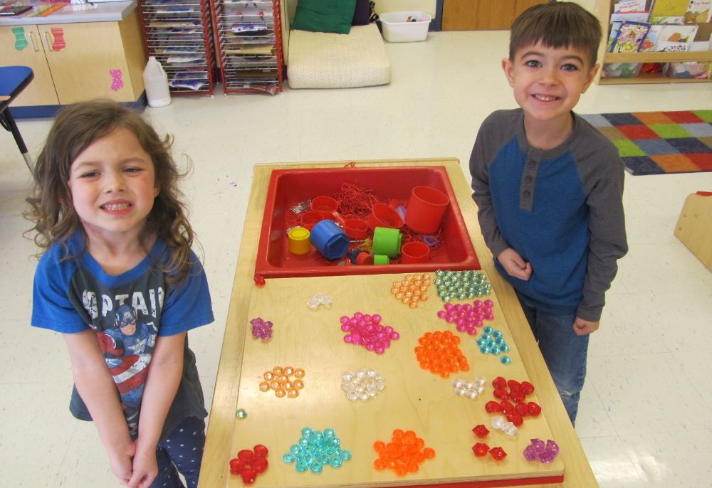 Preschool kids boy and girl playing with colorful educational gem like beads at a Preschool & Daycare/Childcare Center serving Apex & Fuquay-Varina, NC