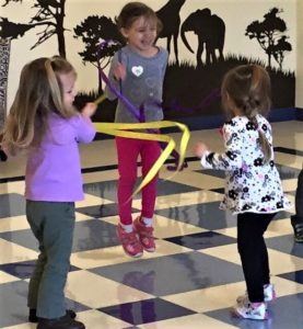 Young little girls jumping, enjoying, and playing with music at a Preschool & Daycare/Childcare Center serving Apex & Fuquay-Varina, NC